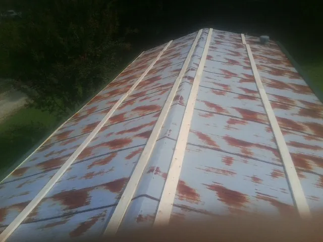 Rusted metal roof panels with new wood purlins before replacement — Storm Damage Roof Repair in Stirum by Roofing Brothers